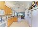 View of kitchen with white appliances and tile floors, open to the dining and living area at 417 Tortuga Dr, Nokomis, FL 34275