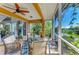 Relaxing screened porch featuring comfortable seating with lovely water views and a cooling ceiling fan at 417 Tortuga Dr, Nokomis, FL 34275