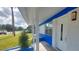 View of the front door, window, blue paint, and carport of this charming home at 4328 Webber St, Sarasota, FL 34232