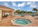 Community pool area with hot tub, lounge chairs, tables and a covered pavilion on a sunny day at 4480 Cinnamon Dr # 2408, Sarasota, FL 34238