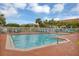 Inviting community pool surrounded by lounge chairs, palm trees and a secure fence at 4480 Cinnamon Dr # 2408, Sarasota, FL 34238