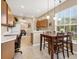 Kitchen area with view of the adjacent dining area featuring wooden cabinets and white counters at 4480 Cinnamon Dr # 2408, Sarasota, FL 34238