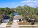 Aerial view of a home with a large yard, nearby lake, mature trees, and a two-car garage at 4627 Breezy Pines Blvd, Sarasota, FL 34232