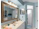 A well-lit, immaculate, and renovated blue bathroom with marble countertops and chrome shower at 4627 Breezy Pines Blvd, Sarasota, FL 34232