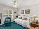 A serene bedroom featuring a daybed, plush chair, and natural light streaming through shuttered windows at 4627 Breezy Pines Blvd, Sarasota, FL 34232