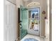 Inviting foyer featuring tile flooring, coat closet, security screen door, and a view of the landscaped front yard at 4627 Breezy Pines Blvd, Sarasota, FL 34232