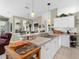 Well-lit kitchen with ample counter space, white cabinetry, and a breakfast bar overlooking the living area at 4627 Breezy Pines Blvd, Sarasota, FL 34232