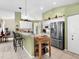 Bright kitchen featuring stainless steel appliances, tiled flooring, and a convenient breakfast bar at 4627 Breezy Pines Blvd, Sarasota, FL 34232