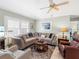 Cozy living room with a large sectional sofa, ceiling fan, and bright natural light at 4627 Breezy Pines Blvd, Sarasota, FL 34232