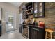 Stylish home bar with wine fridge, stone backsplash, and glass-front display cabinets at 4711 Placid Cir, Sarasota, FL 34231