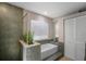 Relaxing bathroom with a separate tub, window with blinds, and large tile walls for a modern touch at 4711 Placid Cir, Sarasota, FL 34231