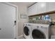 Functional laundry room with white cabinetry, modern washer and dryer, and organized shelving at 4711 Placid Cir, Sarasota, FL 34231
