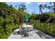 Charming patio seating area surrounded by lush greenery and a decorative black metal fence at 4711 Placid Cir, Sarasota, FL 34231