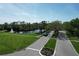 Aerial view of the community entrance, showcasing lush landscaping, a scenic pond with a fountain, and well-maintained grounds at 5211 Mahogany Run # 113, Sarasota, FL 34241