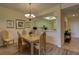 The dining room features wood flooring, a chandelier, seating for six, and views into the kitchen at 5211 Mahogany Run # 113, Sarasota, FL 34241