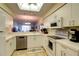 Open kitchen with white cabinetry and a breakfast bar overlooking the living area at 5211 Mahogany Run # 113, Sarasota, FL 34241