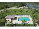 Aerial view of the community pool and clubhouse with lush landscaping, lounge chairs, and sparkling water at 5211 Mahogany Run # 113, Sarasota, FL 34241