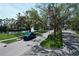 Scenic entrance showcasing lush landscaping, a serene pond, and an American flag at 5211 Mahogany Run # 113, Sarasota, FL 34241