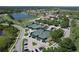 Aerial view of community tennis courts next to a lake and golf course with parking and mature trees at 5211 Mahogany Run # 113, Sarasota, FL 34241