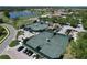 Aerial view of community tennis courts next to a lake and golf course with parking and mature trees at 5211 Mahogany Run # 113, Sarasota, FL 34241