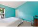 Bright bedroom with a white comforter, aqua wall, and modern black dresser with decorative decor at 5227 Lansdowne Way, Palmetto, FL 34221