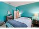 Bedroom with bold aqua walls, neutral carpet, and well-appointed furnishings including a fan and modern lamps at 5227 Lansdowne Way, Palmetto, FL 34221