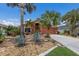 Charming single-story home with a beautiful, lush tropical landscaped front yard and a matching terracotta-colored exterior at 5227 Lansdowne Way, Palmetto, FL 34221