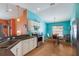 Modern kitchen with stainless steel appliances, white cabinets, and contrasting turquoise and orange walls at 5227 Lansdowne Way, Palmetto, FL 34221