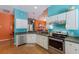 Well-appointed kitchen with stainless steel appliances, white cabinetry, and a breakfast bar overlooking the dining area at 5227 Lansdowne Way, Palmetto, FL 34221