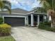 Charming single-story home with a two-car garage, manicured landscaping, and columned front porch at 5262 Asher Ct, Sarasota, FL 34232