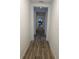 Hallway with gray wood flooring leading to the kitchen at 5262 Asher Ct, Sarasota, FL 34232