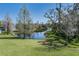 Scenic backyard view with a serene pond, lush greenery, and mature trees at 5412 72Nd E Ter, Ellenton, FL 34222