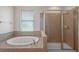 Bathroom with an oval soaking tub and a separate glass-enclosed shower at 5412 72Nd E Ter, Ellenton, FL 34222