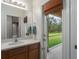 Bright bathroom featuring a single sink vanity with a view to the screened-in lanai at 5412 72Nd E Ter, Ellenton, FL 34222