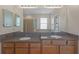 Bathroom with a double vanity, a large mirror, and wood cabinets at 5412 72Nd E Ter, Ellenton, FL 34222