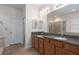 Bathroom featuring double sinks, wood cabinetry and tile flooring at 5412 72Nd E Ter, Ellenton, FL 34222