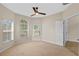 A bright bedroom with three windows, neutral carpet, ceiling fan, and a white door at 5412 72Nd E Ter, Ellenton, FL 34222