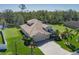 Beautifully landscaped home with a three-car garage, long brick driveway, green lawn, and a serene view of the water and wooded area at 5412 72Nd E Ter, Ellenton, FL 34222