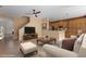 An open-concept living room with a staircase, a TV, a couch, and a view into the kitchen at 5412 72Nd E Ter, Ellenton, FL 34222