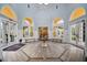 Grand lobby with arched windows, tiled floor, chandelier, and seating, creating an inviting and elegant entrance at 5450 Bentgrass Dr # 5-301, Sarasota, FL 34235