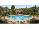 Upscale community pool with ample seating, a covered lounge area, and tropical landscaping at 5450 Bentgrass Dr # 5-301, Sarasota, FL 34235