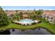 Community pool with surrounding seating areas and lush landscaping, enclosed by a black fence and a pond nearby at 5450 Bentgrass Dr # 5-301, Sarasota, FL 34235