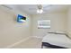 A clean and modern bedroom with a minimalist aesthetic, featuring tile flooring, a TV, and a window at 5562 Hayden Blvd, Sarasota, FL 34232