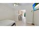 Bright bedroom with tile flooring, ceiling fan and mounted TV, open to kitchen at 5562 Hayden Blvd, Sarasota, FL 34232