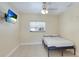 Bright bedroom with tile flooring, ceiling fan and mounted TV at 5562 Hayden Blvd, Sarasota, FL 34232