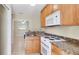 Functional kitchen featuring light wood cabinets, granite countertops, and modern appliances at 5562 Hayden Blvd, Sarasota, FL 34232