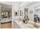 Bathroom featuring double sinks, a large mirror and doorway view to the main bedroom at 5568 Ashton Lake Dr # 5568, Sarasota, FL 34231