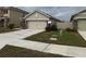 Beige single story home with a 2 car garage, stone accents and well maintained front yard at 5838 Elegant Orchid Way, Sarasota, FL 34232