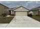 Beige single story home with a 2 car garage, stone accents and well maintained front yard at 5838 Elegant Orchid Way, Sarasota, FL 34232