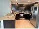Well-equipped kitchen features dark cabinets, granite countertops, stainless steel appliances, and tiled flooring at 5838 Elegant Orchid Way, Sarasota, FL 34232